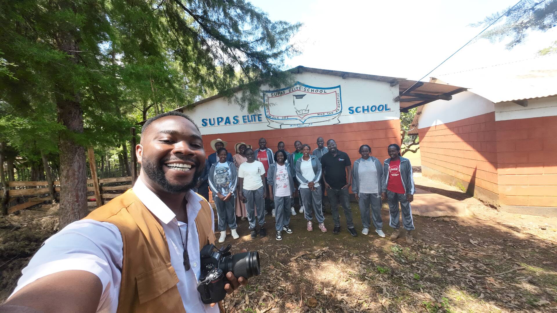 Nathaniel shares a group selfie moment with the staff of Supas Elite School in Western Kenya.